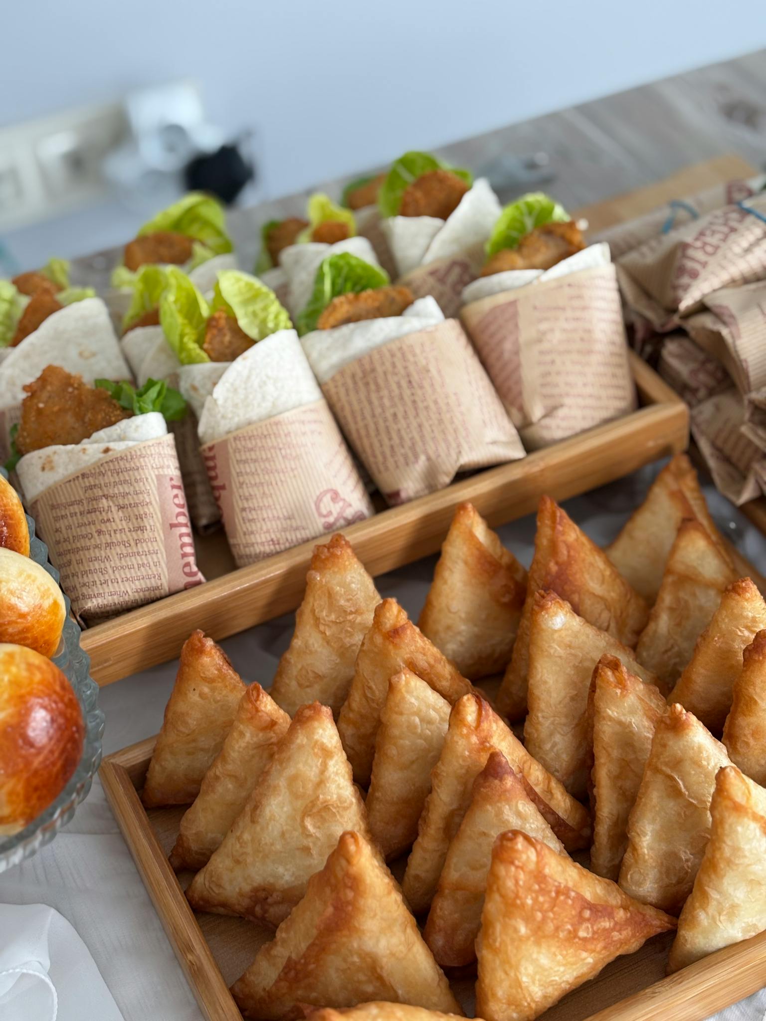 A tempting assortment of samosas and wraps with lettuce and cutlets, perfect for party appetizers.