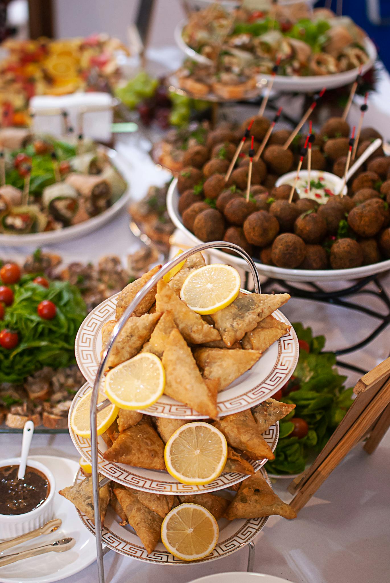 A Vibrant Buffet Featuring Assorted Appetizers Including Samosas Meatballs And Fresh Greens Elegantly Displayed. 19659620 1371x2048
