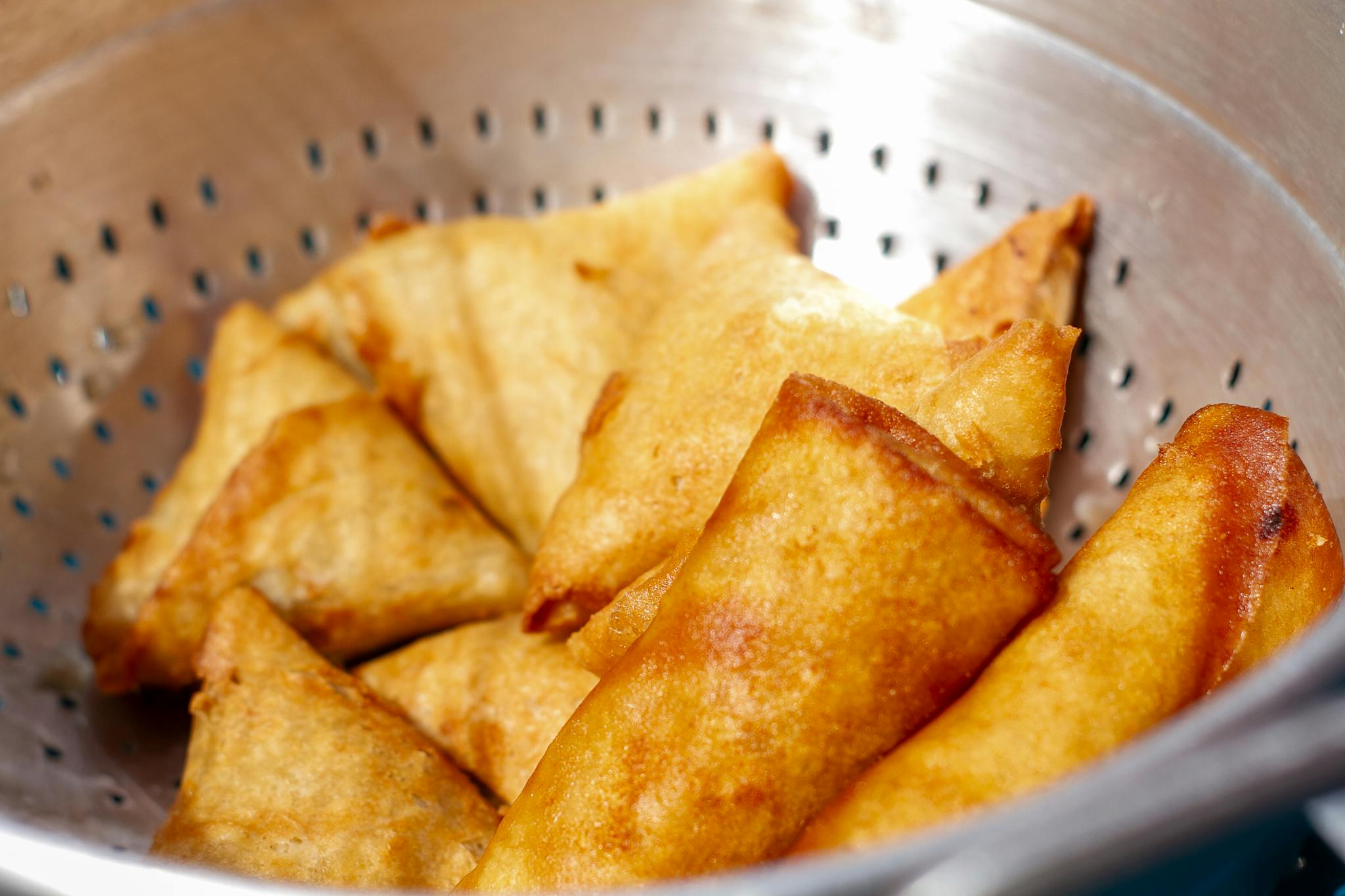 Home Close Up Of Golden Fried Samosas Cooling In A Metal Colander Perfect Snack. 29037272 2048x1365